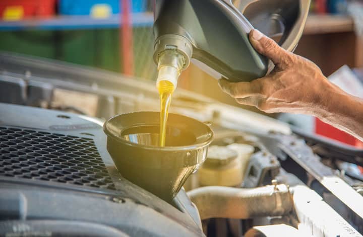 Top 13 Best Motor Oil For Cold Weather That Your Car Engine Deserves! 7 man pouring oil into car royalty free image 1598901693